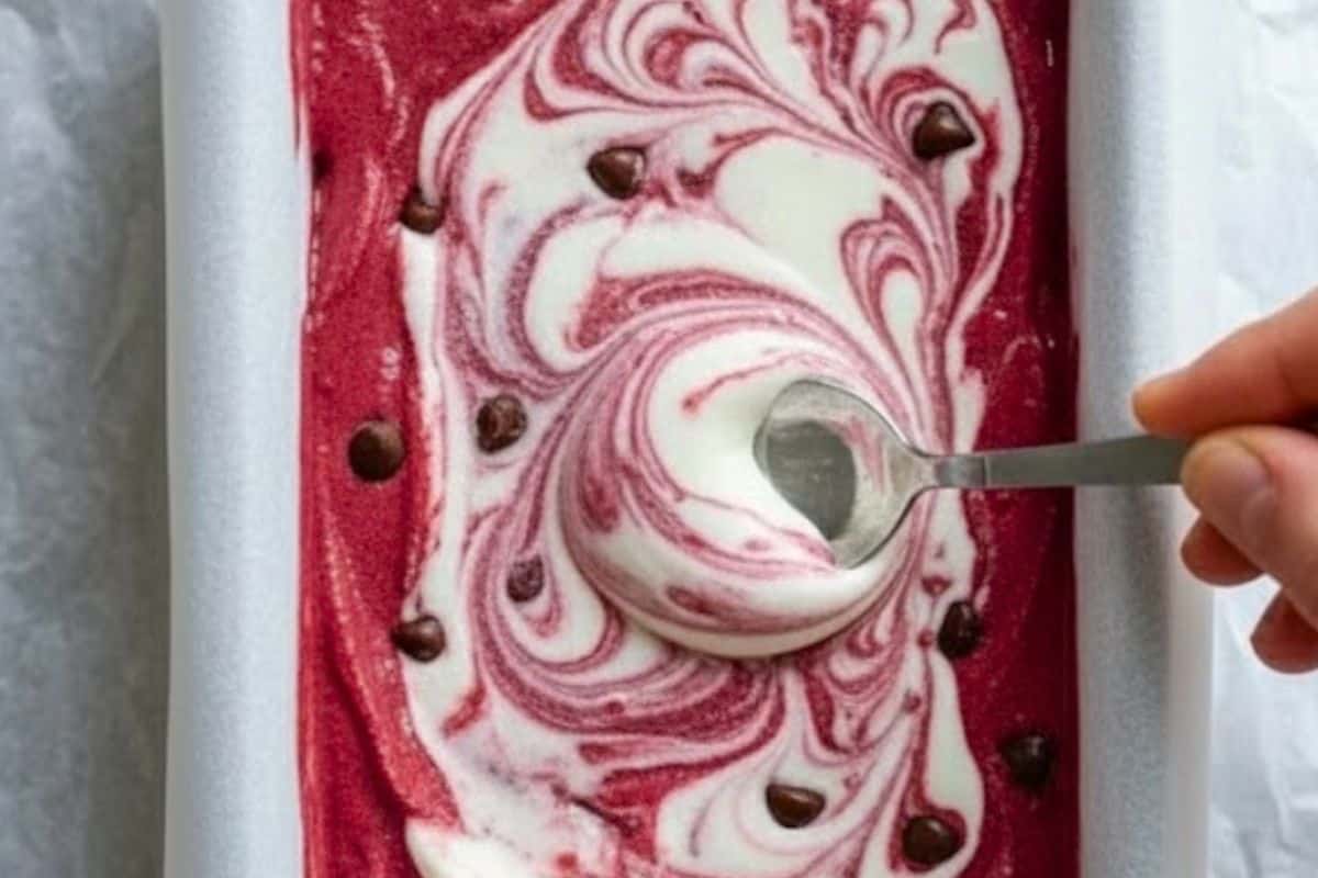 Pour the cream cheese mixture over the red velvet base, swirl gently, and freeze