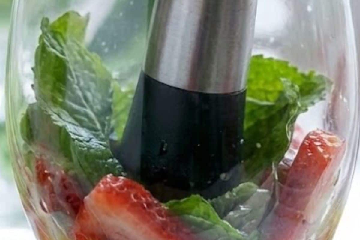 Divide mint leaves and sliced strawberries between four glasses, juice one lime and add about a teaspoon to each, then gently muddle - 6