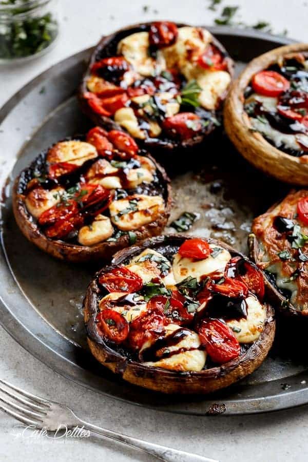 Caprese Stuffed Garlic Butter Portobellos! Garlic butter portobello mushrooms stuffed and grilled with fresh mozzarella cheese, grape tomato slices and drizzled with a rich balsamic glaze! Low carb, healthy and perfect to enjoy for lunch, dinner or as a filling snack! | https://cafedelites.com
