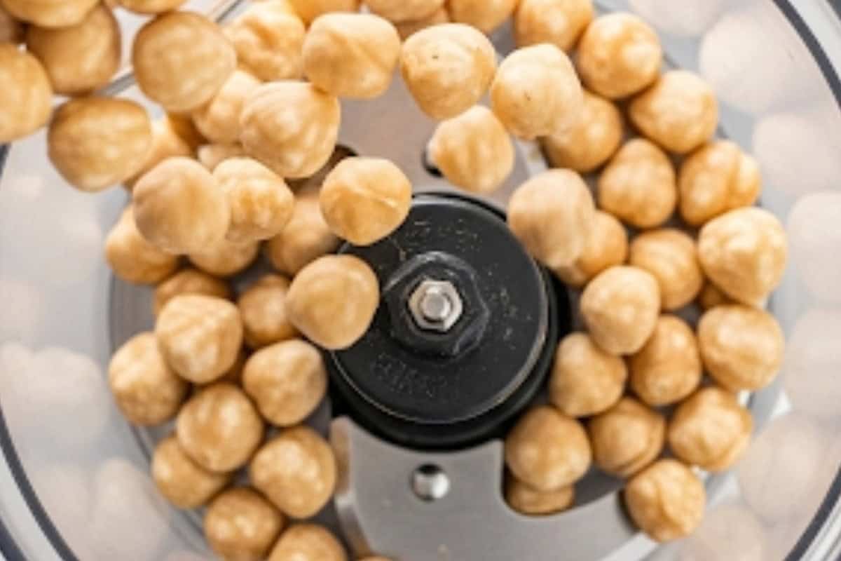 Remove the skin of the hazel nut and transfer the peeled hazelnuts to a food processor.