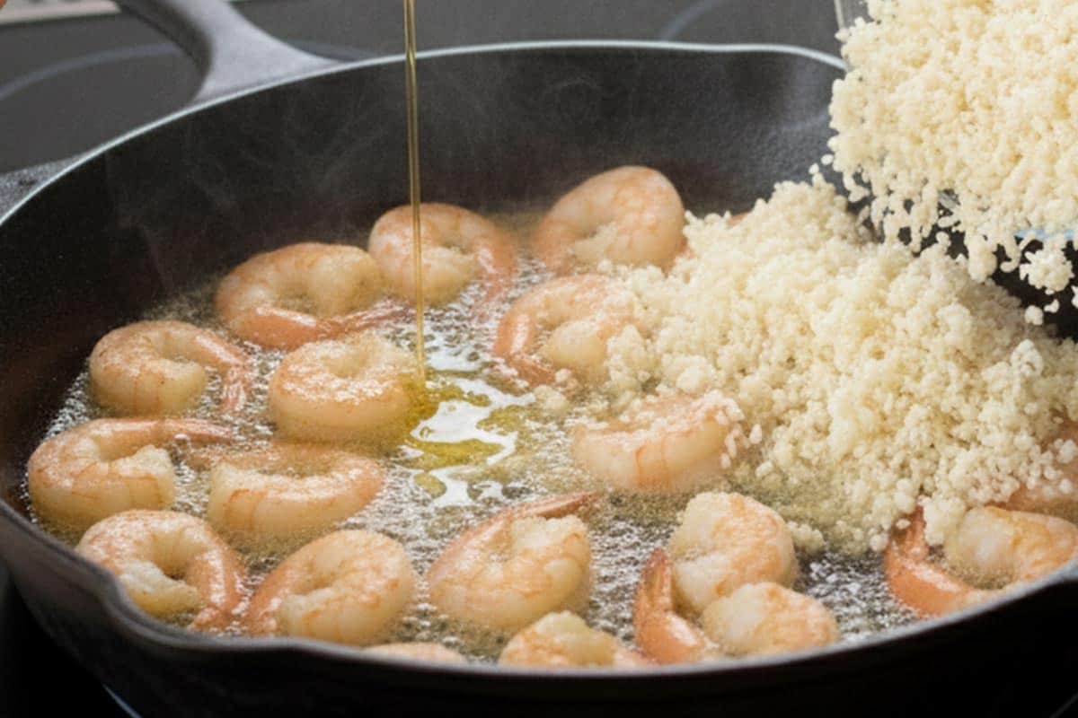 Pouring olive oil and cauliflower to the pan.