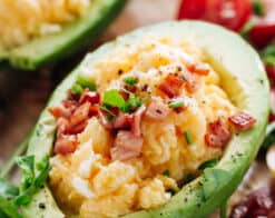 Soft scrambled eggs with stringy cheese and crispy bacon stuffed into avocado
