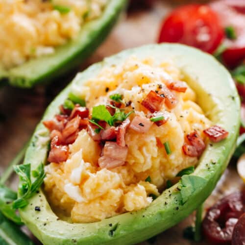 Yummy Soft scrambled eggs with stringy cheese and crispy bacon stuffed into avocado