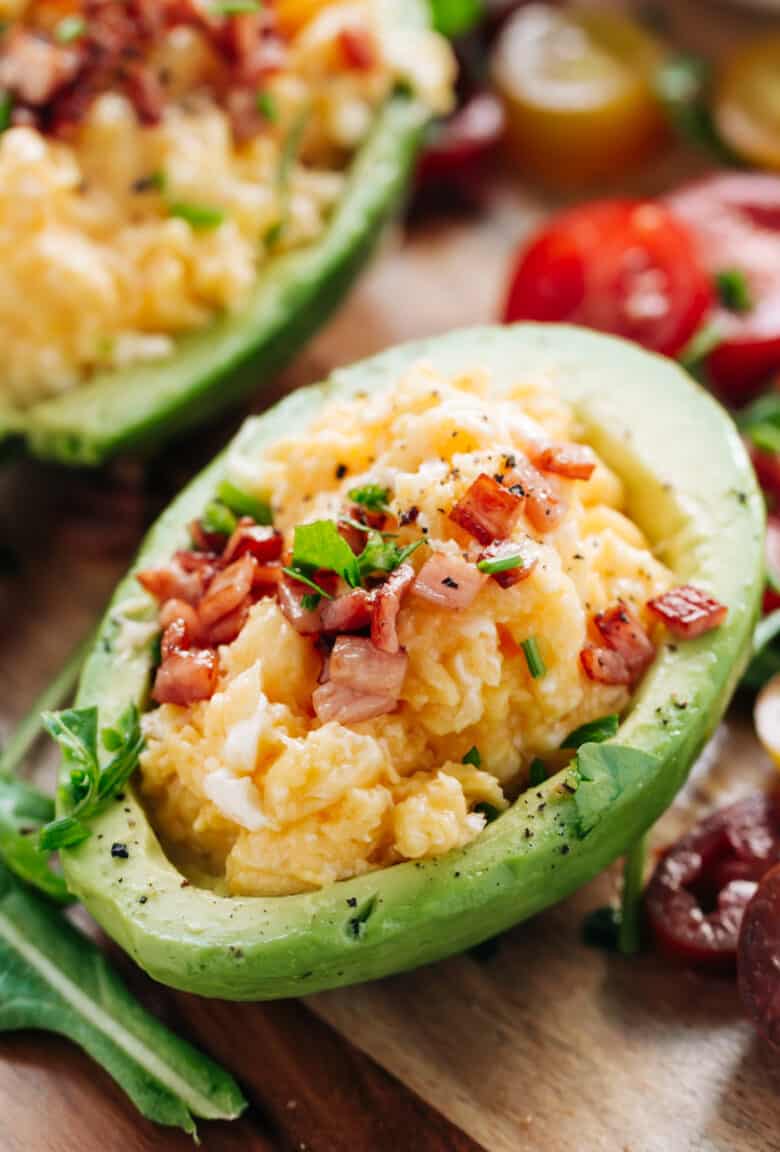Soft scrambled eggs with stringy cheese and crispy bacon stuffed into avocado