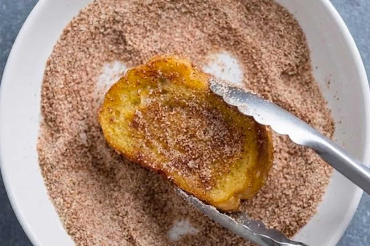 Transfer each hot toast directly into the cinnamon sugar mixture and coat both sides evenly.