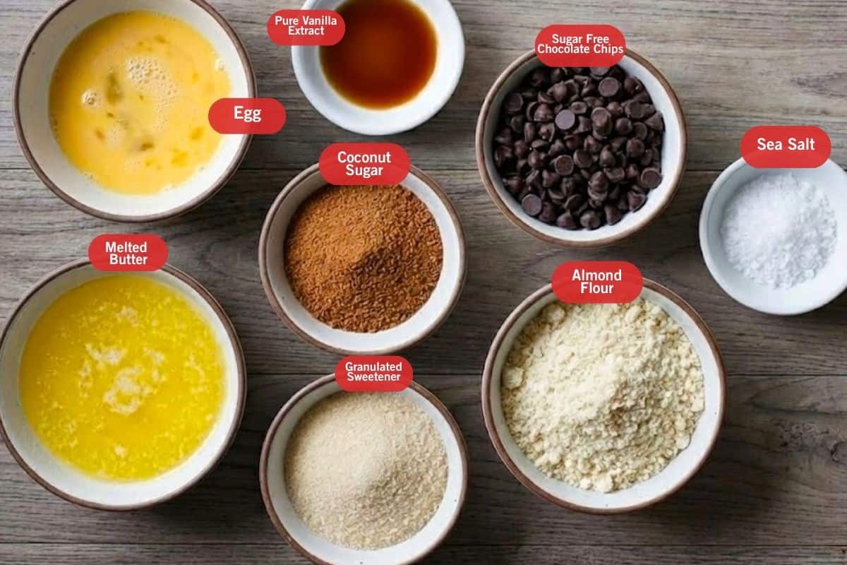 Flat lay photo of ingredient shot of Egg, pure vanilla extract, sugar free chocolate chips, sea salt, almond flour, granulated sweetener, melted butter, pure vanilla extract