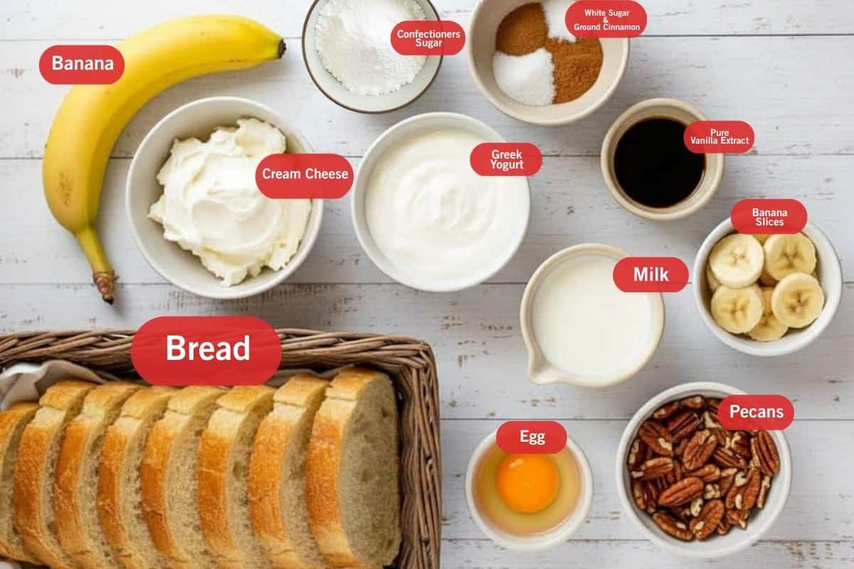 Flat lay photo of ingredient shot of banana, confectioner sugar, white sugar and ground cinnamon, pure vanilla extract, banana slice, milk, greek yogurt, cream cheese, bread, egg, pecans
