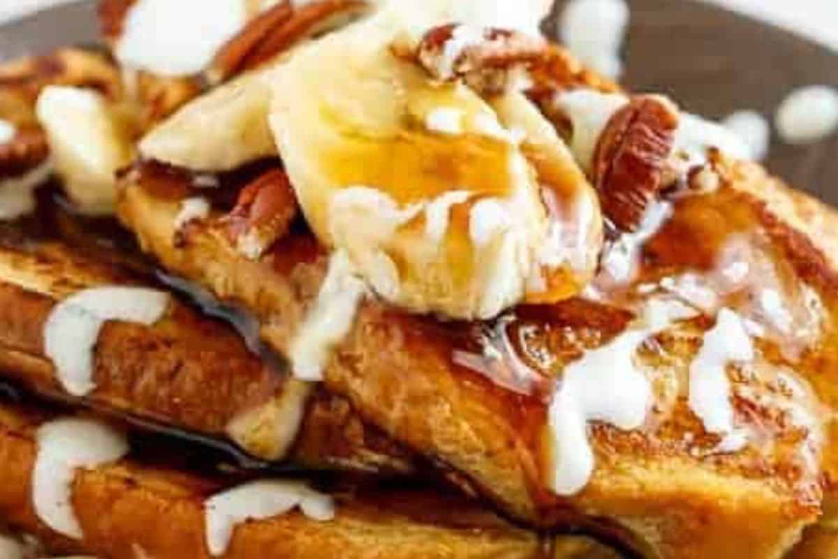 Stack the toasts, drizzle with the cream cheese glaze, and top with banana slices and pecans.