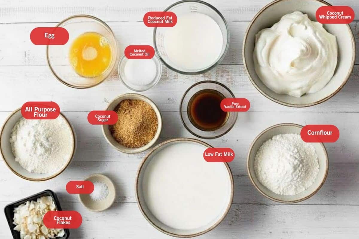 Flat lay photo of ingredient shot of egg, melted coconut oil, reduced fat coconut milk, coconut whipped cream, cornflour, low fat milk, salt, coconut flakes, all purpose flour, coconut sugar, pure vanilla extract