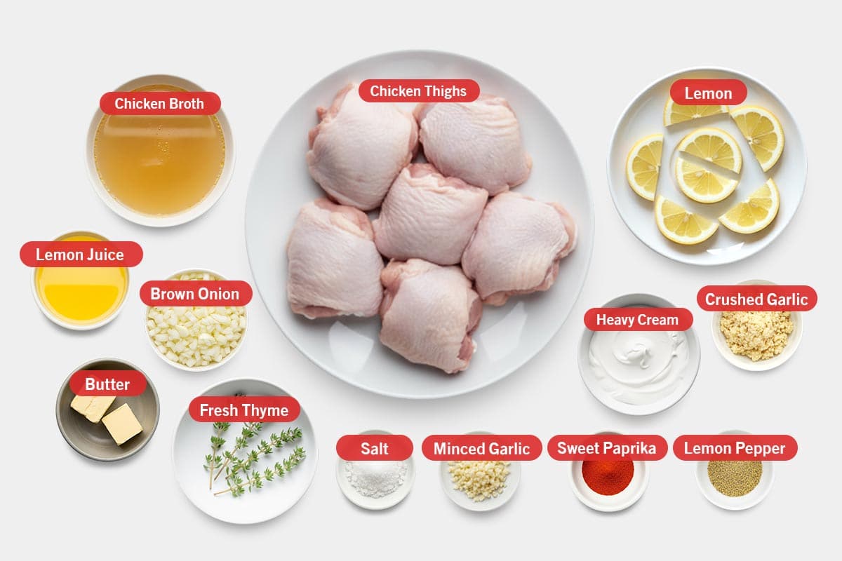 Top shot of ingredients: Chicken broth, chicken thighs, lemon, lemon juice, brown onion, butter, fresh thyme, salt, minced garlic, sweet paprika, lemon pepper, heavy cream, and crushed garlic.