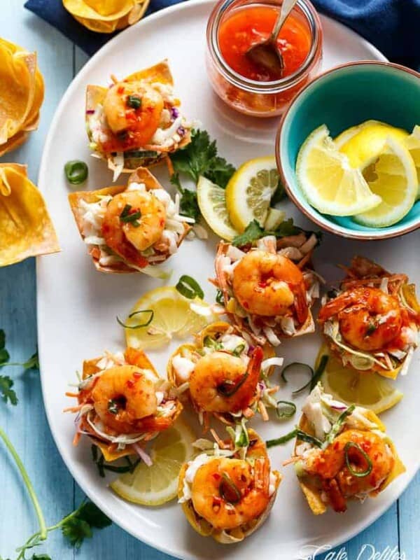 Garlic Prawn (Shrimp) Salad Wonton Cups with Sweet Chilli Sauce with lemon wedges in a small bowl