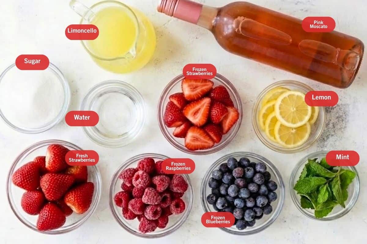 Flat lay photo of sugar, limoncello, pink moscato, lemon,  mint, frozen blueberries, frozen raspberries, fresh strawberries, water, frozen strawberries - 2