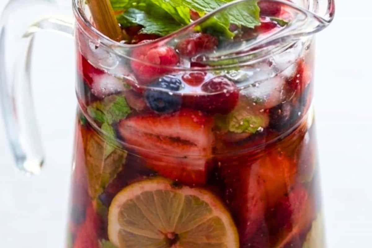 In a pitcher, combine 1/4 cup strawberry syrup, moscato, limoncello, frozen berries, mint leaves, and lemon slices. - 6