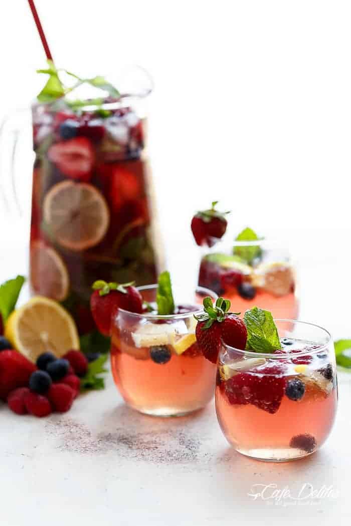 A beautiful and refreshing spin on a traditional sangria using a mixture of frozen berries for a full berry flavour, a simple to make strawberry syrup, and the sweet Italian tangy-sweet citrus from limoncello! | https://cafedelites.com