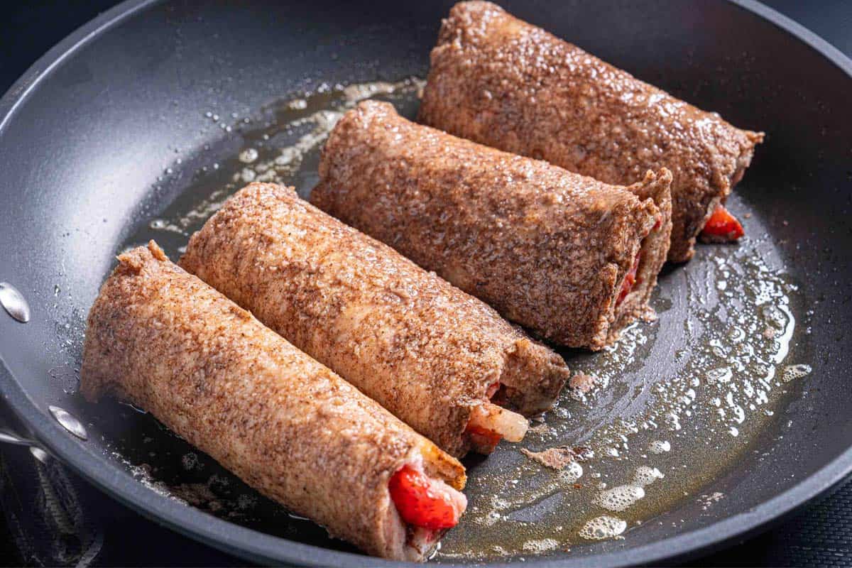 Image of the dipped rolls being cooked in a skillet.