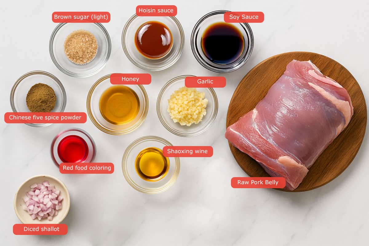 Top-down view of Char Siu ingredients in glass bowls, including hoisin sauce, soy sauce, Shaoxing wine, honey, brown sugar, garlic, red food coloring, five spice powder, and pork belly on a wooden board.