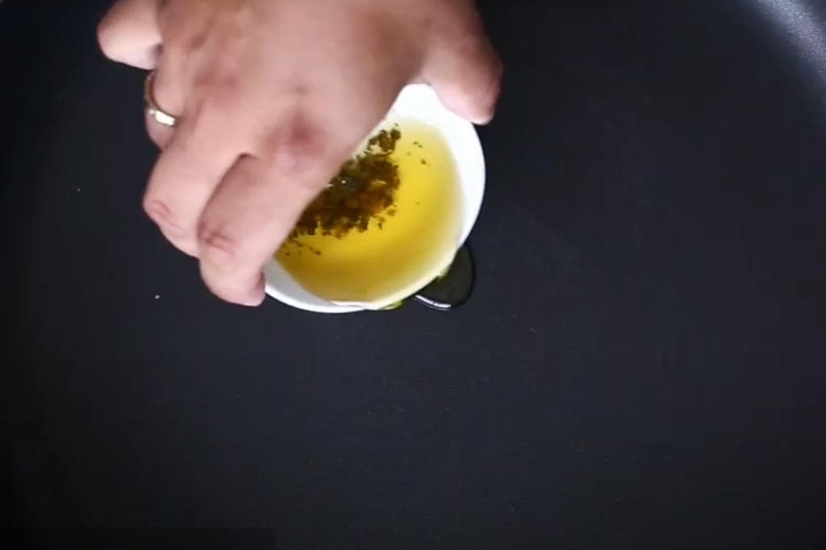Putting sun dried tomato oil in a nonstick skillet.