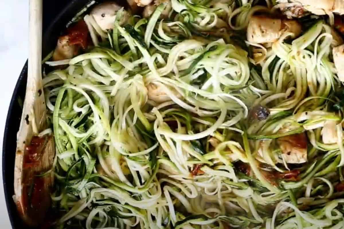 Stirred in sun dried tomatoes add the zucchini noodles.