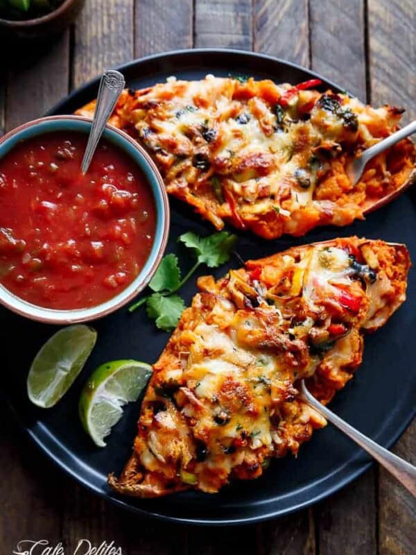 Chicken Fajita Sweet Potatoes with red sauce and lemon wedges on a plate