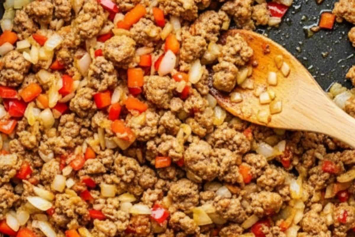 Add garlic, red bell pepper, and sausage with cumin, paprika, and chili; cook, stirring, until the sausage is browned and the spices are fragrant in a nonstick pan.