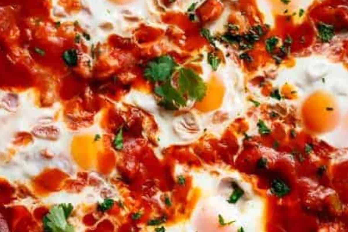 Make six small wells in the sauce with a spoon and crack one egg into each well. 