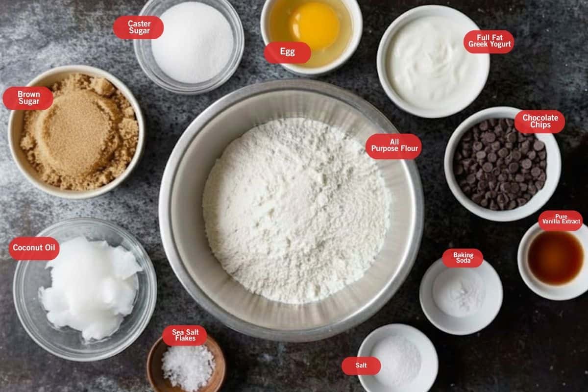 Flat lay photo of ingredients shot of brown sugar, caster sugar, egg, full fat greek yogurt, chocolate chips, pure vanilla extract, baking soda, salt, sea salt flakes, coconut oil in solid state