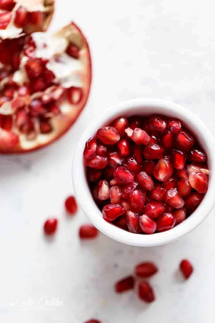  throwing fresh ingredients into a bowl with an abundance of Pomegranates Pomegranate Cobb Salad