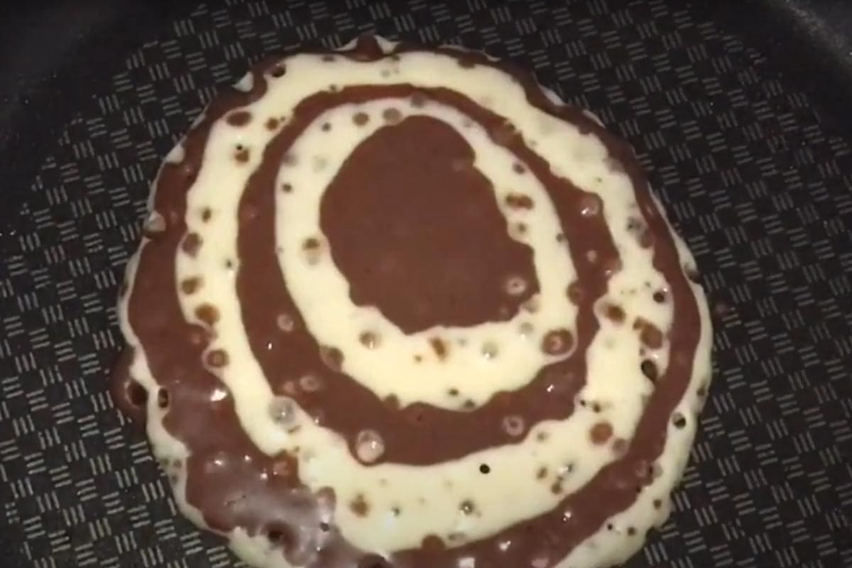 Cooking until bubbles appear on the surface.