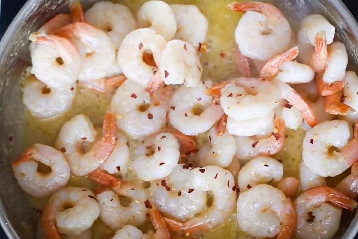 Seasoning the shrimp with salt, pepper, and red pepper flakes. - 8