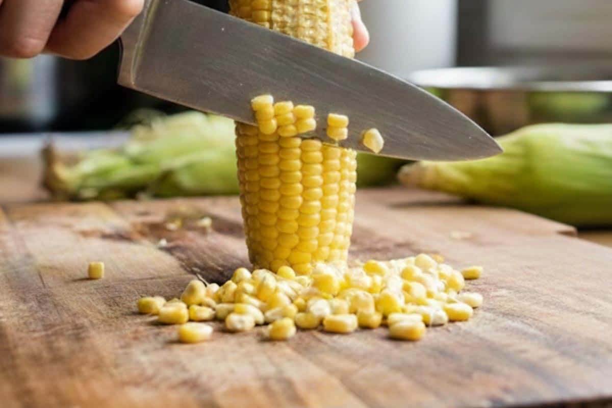 Removing the kernels of the corn using a knife. - 4