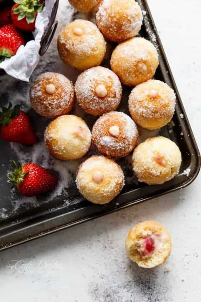 Lightened up soft and fluffy Strawberry Cheesecake Donut Holes, filled with sweet strawberry and creamy cheesecake filling! on a tray