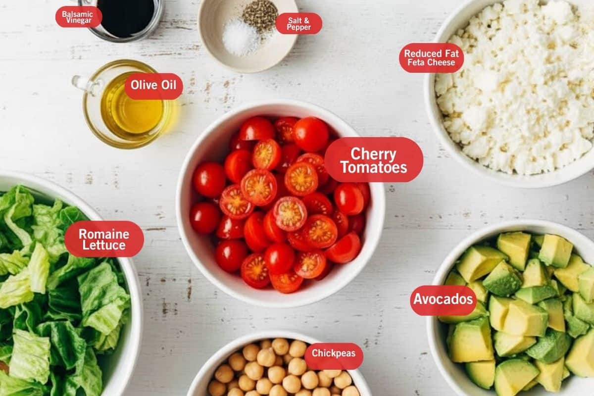 Flat lay photo of ingredient shot of balsamic vinegar, salt and pepper, reduced fat feta cheese, cherry tomatoes, avocados, romaine lettuce, chickpeas