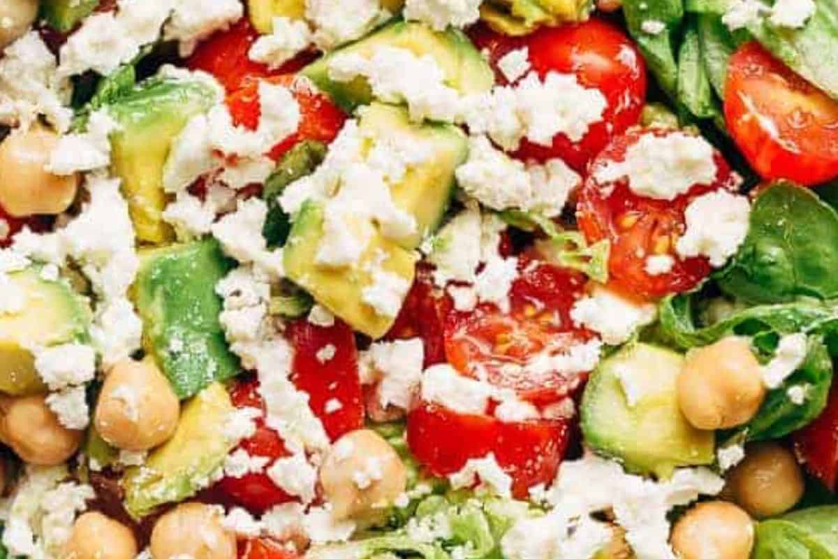 In a jug, whisk together oil and balsamic vinegar. Pour the dressing over the salad, season with salt and pepper to taste.