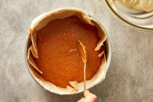 round pan being layered with carrot mix