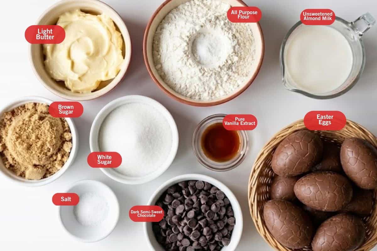 Flat lay photo of ingredient shot of light butter, all purpose flour, unsweetened almond milk, easter eggs, pure vanilla extract, dark semisweet chocolate, white sugar, salt, brown sugar.
