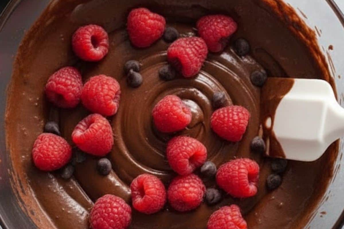 Fold in three fourths cup of raspberries and one third of the chocolate chips