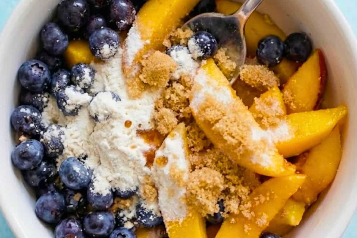 Preheat oven to 350°F (175°C). Place blueberries and mango slices in an 8-inch baking dish, then add flour, sugar and vanilla and coat evenly.