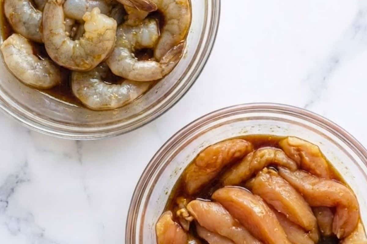 Pat the shrimp dry and coat them with two tablespoons of the sauce. Coat the chicken strips with one tablespoon of sauce and set both aside. - 4