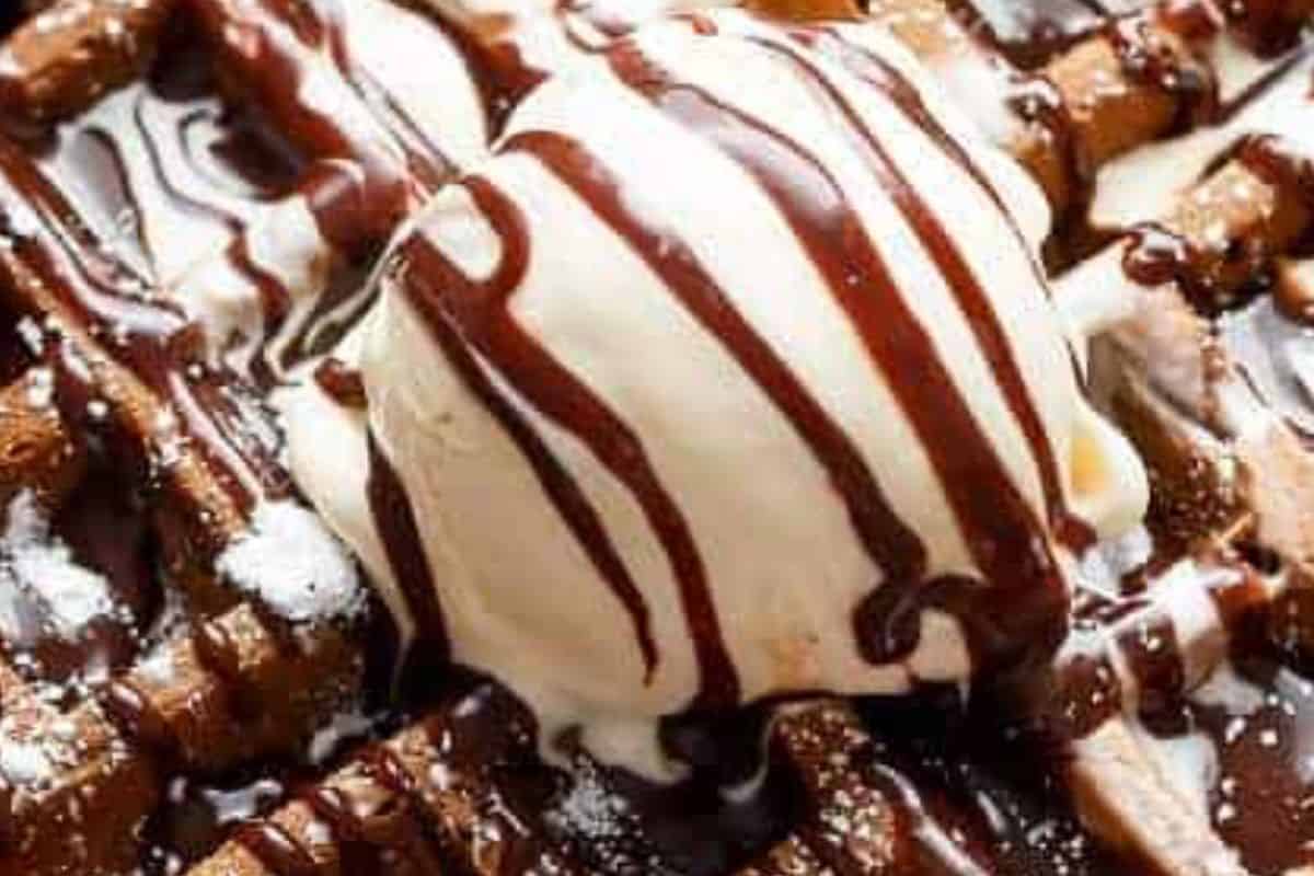Plate the warm chocolate waffles with a dusting of powdered sugar or sweetener, and drizzle generously with melted Nutella.