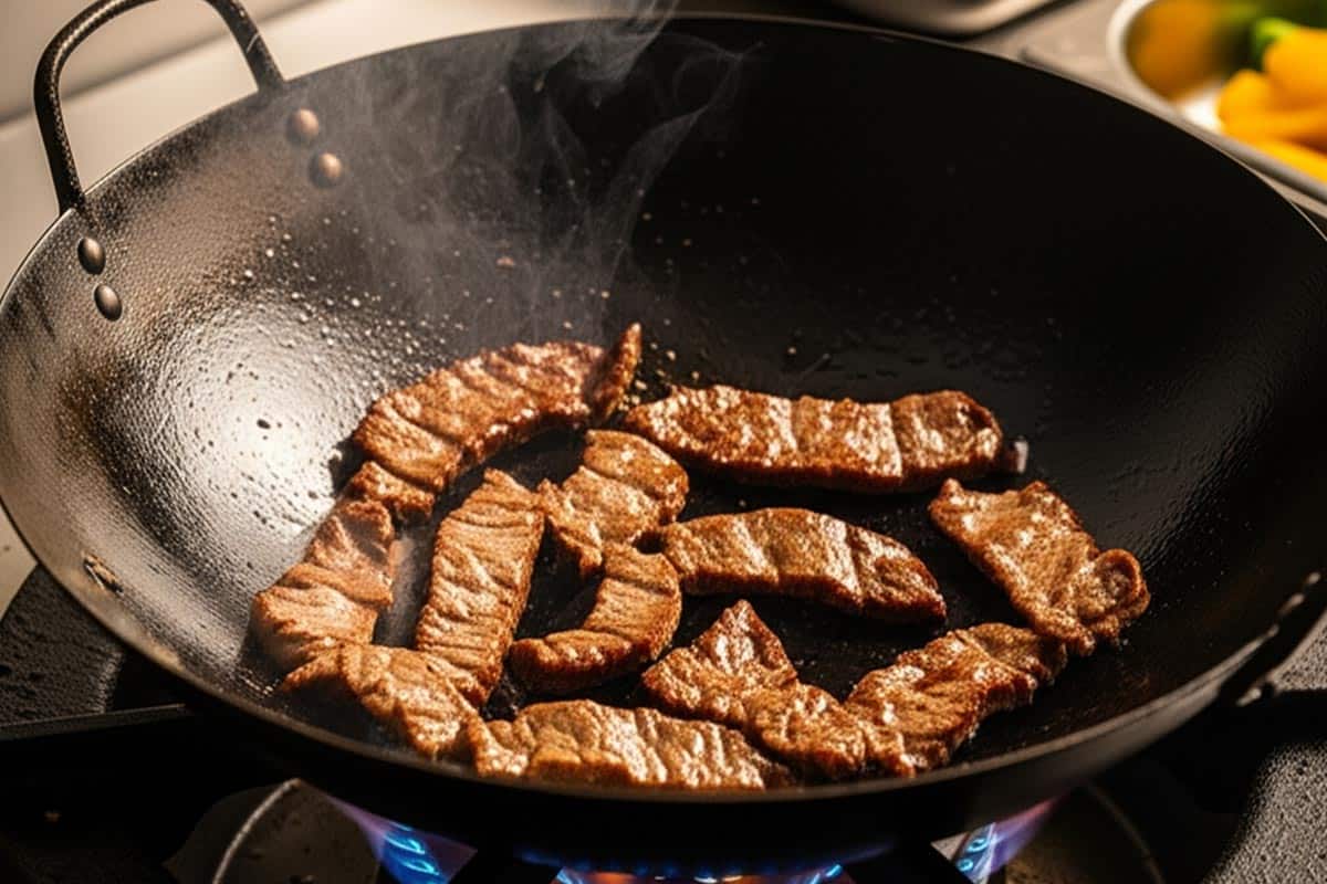 Cooking the beef in a wok.