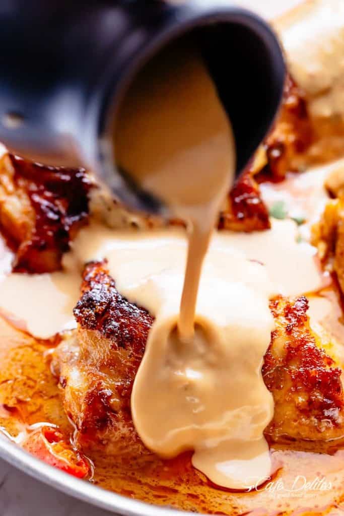 A Creamy Peanut Sauce being poured on Thai Satay Chicken 