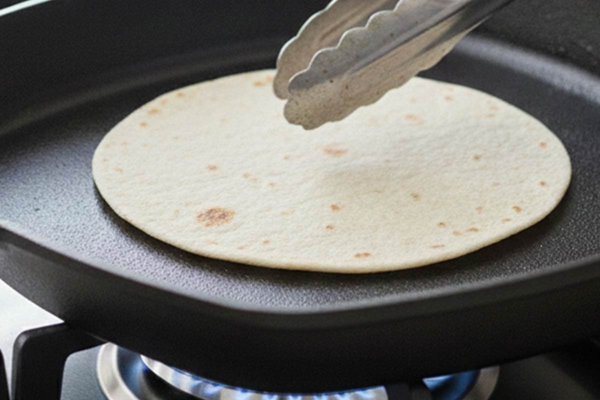 Heating the tortillas in a pan. - 8