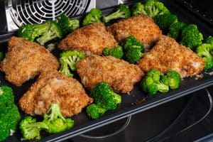 Broccoli and and oven fried chicken inside oven
