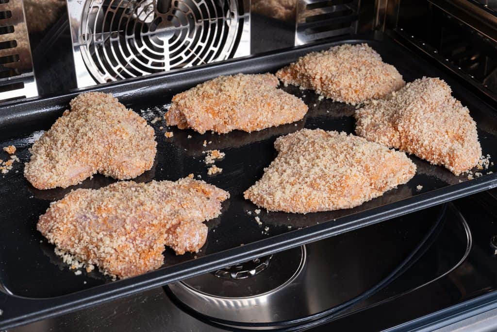 crumbed and coated chicken sitting on a baking tray