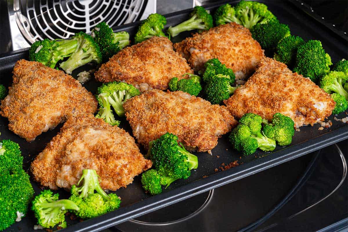 Broccoli and and oven fried chicken inside oven