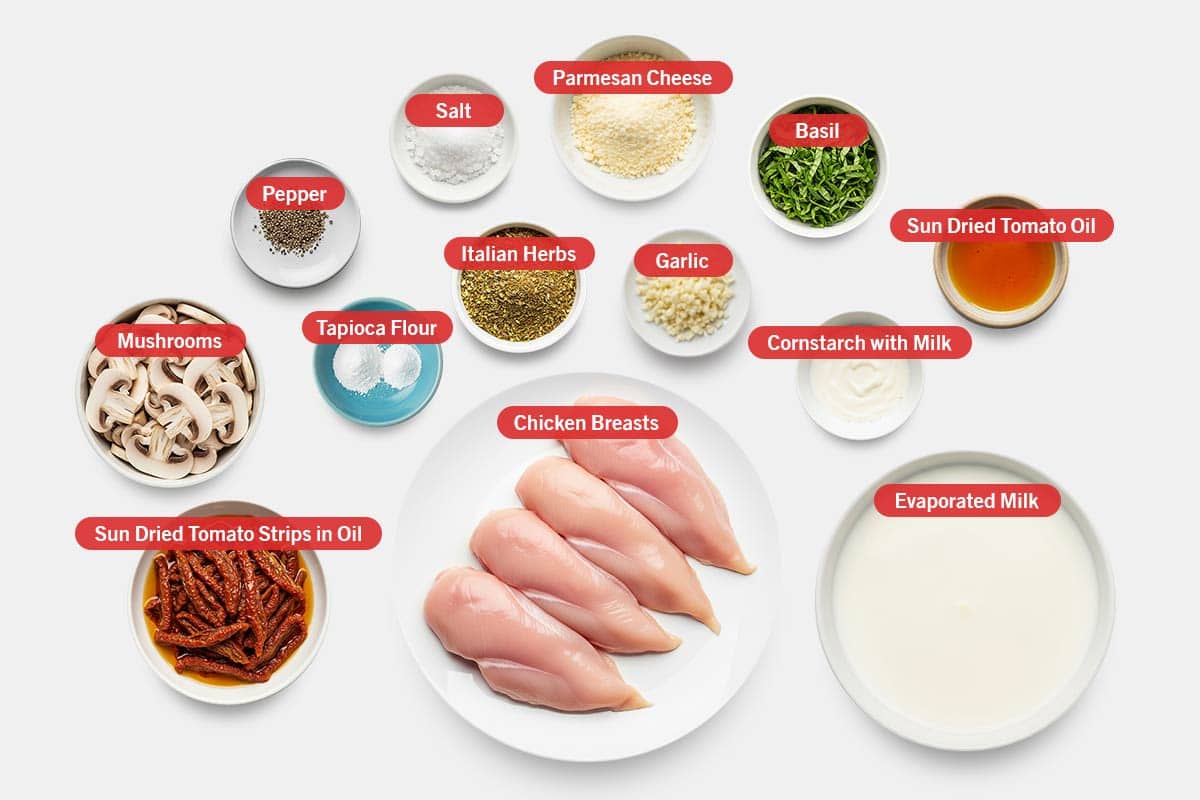 Top shot of ingredients: Mushrooms, pepper, salt, parmesan cheese, basil, sun dried tomato oil, tapioca flour, Italian herbs, garlic, cornstarch with milk, sun dried tomato strips in oil, chicken breasts, and evaporated milk.