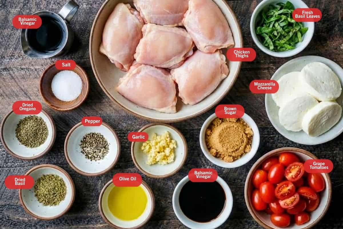 Flat lay photo of ingredient shot of balsamic vinegar, chicken thighs, fresh basil leaves, mozzarella cheese, brown sugar, grape tomatoes, olive oil, pepper, salt, garlic, dried basil, dried oregano, salt.