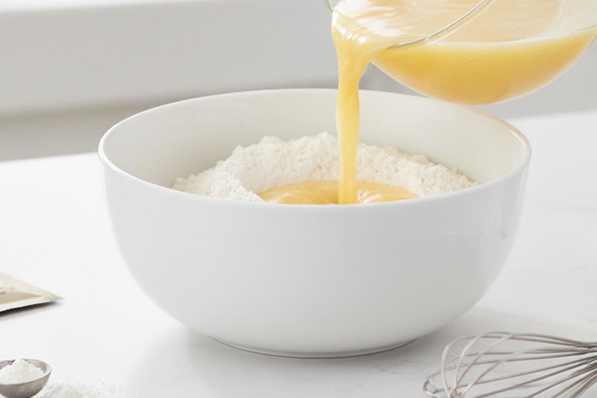 Pouring the wet mixture into the dry ingredients.