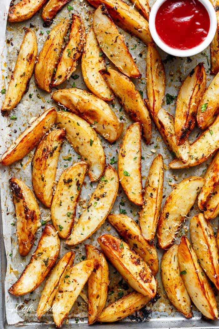 Crispy Garlic Baked Potato Wedges are soft pillows on the inside, and crunchy on the outside with a good kick of garlic and parmesan cheese! | https://cafedelites.com