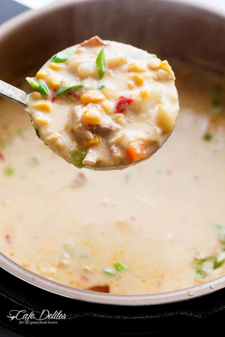 A ladle lifting creamy, chunky soup from a pot. 